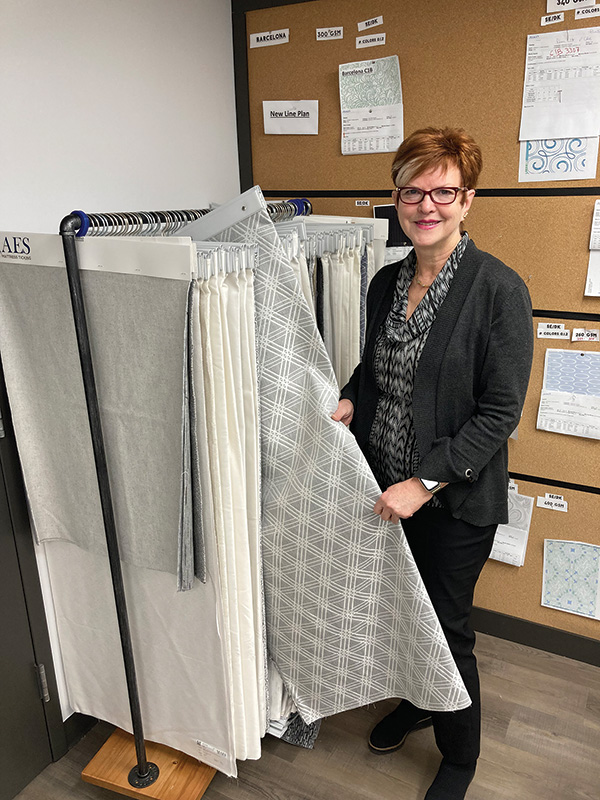 Creative Vice President of Design and Marketing Camilla Franklin shows off a stylish gray fabric in the design studio.